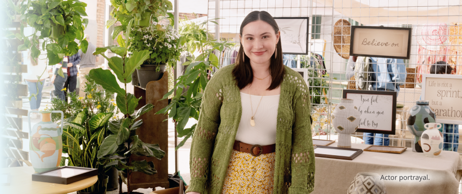 A person, light-skinned and feminine-presenting in their twenties, smiling at an outdoor market. Actor portrayal.