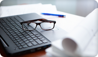 Glasses resting on a laptop. ​