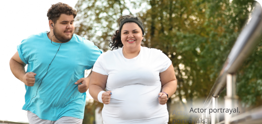 Two medium skin toned people walking on a trail on a bright morning. Actor portrayals.​